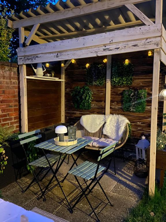 eine Terrasse mit Tisch und Stühlen unter einer Pergola in der Unterkunft Maisonnette individuelle au coeur de Vernon in Vernon