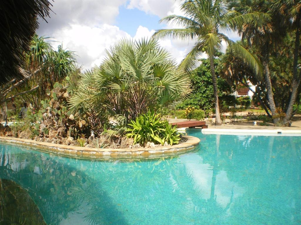 una gran piscina con palmeras en el fondo en Kilimandogo Residence en Malindi