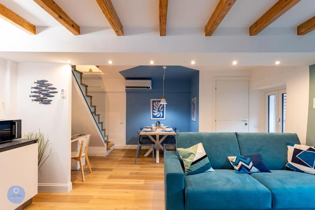ein Wohnzimmer mit einem blauen Sofa und einem Tisch in der Unterkunft Nido Blu - Vista Lago in Belgirate