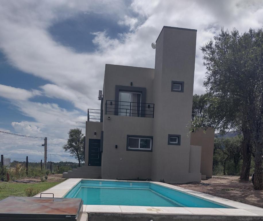 a house with a swimming pool in front of a house at Mi lugar en el mundo in Cortaderas