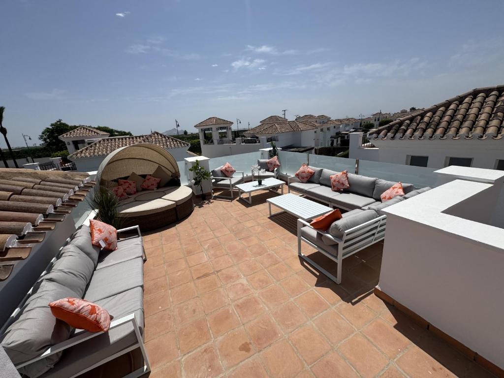 a patio with couches and chairs on a roof at Villa Ohana - A Murcia Holiday Rentals Property in Roldán