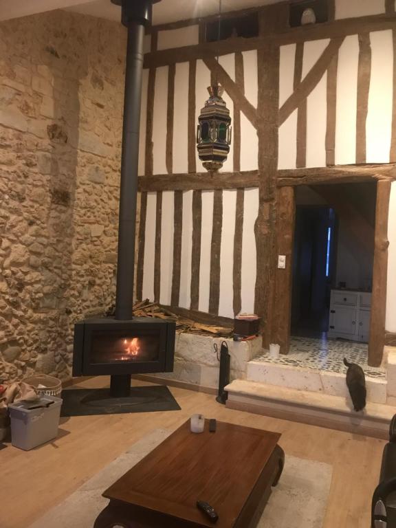 a living room with a fireplace and a wood stove at Maison de charme in Cercoux