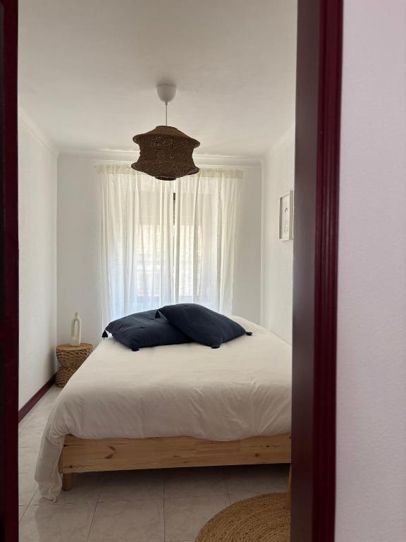 a bedroom with a bed with a window at Casa Eça in Sesimbra