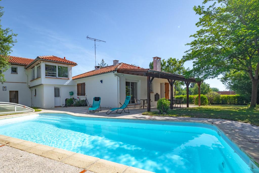 a swimming pool in front of a house at L'Oasis de rêve villa 5 chambre avec piscine in Pibrac