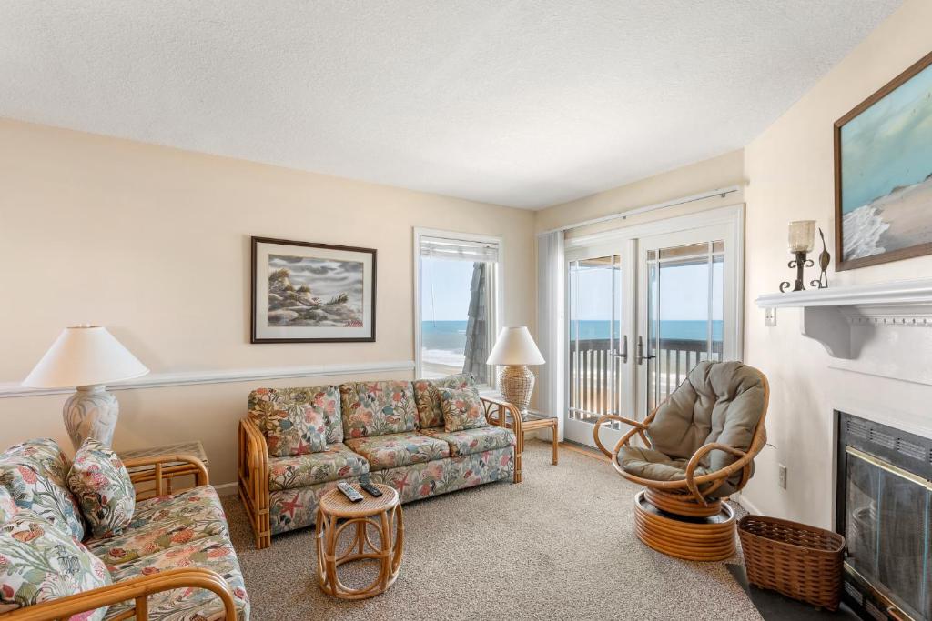 a living room with a couch and a fireplace at Golden Strand Unit C3 in Kill Devil Hills
