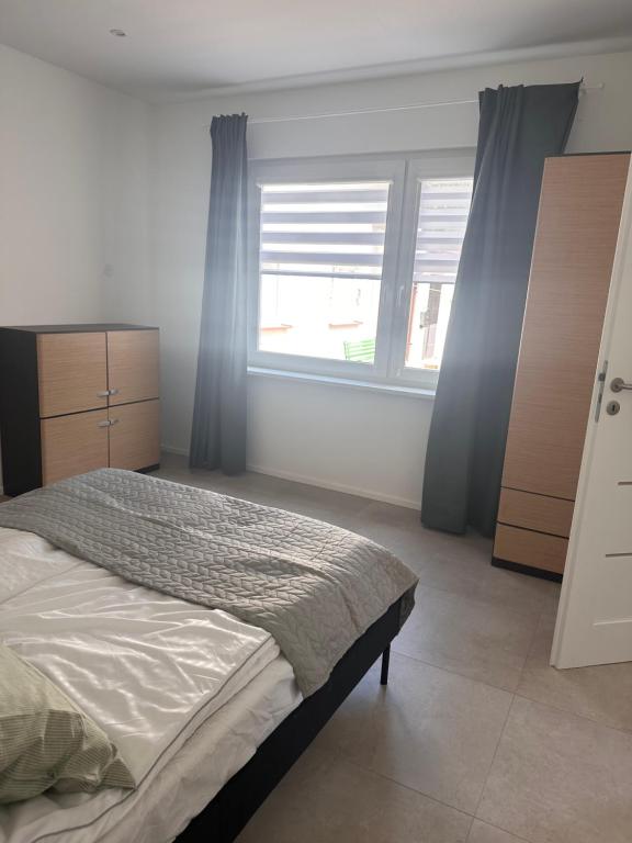ein Schlafzimmer mit einem Bett und einem großen Fenster in der Unterkunft Przystanek Bałtyk in Misdroy