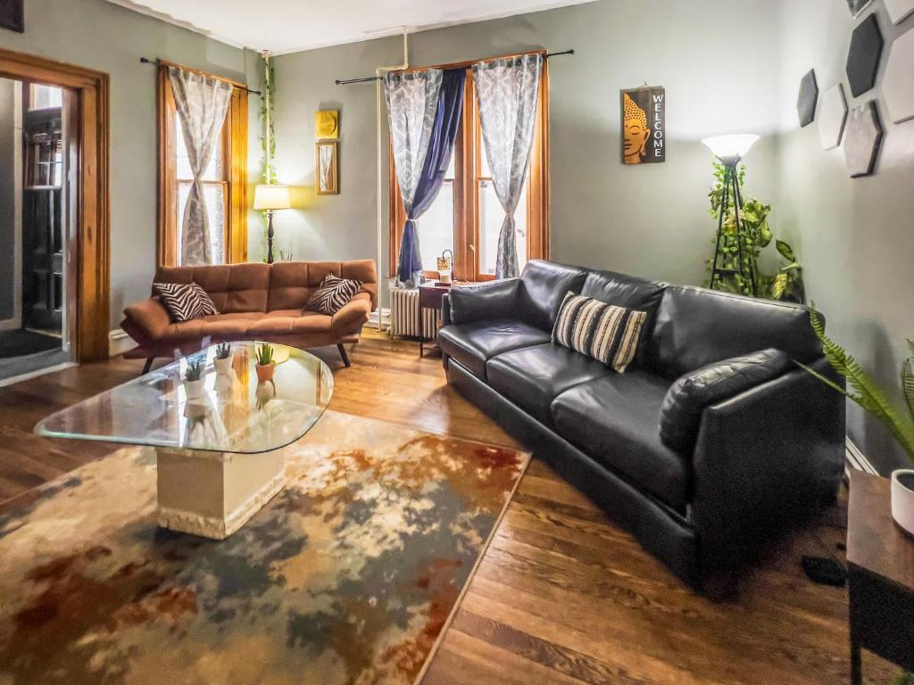 a living room with a leather couch and a glass table at Walk to Trinity Hartford 2BR Gem Barry Square in Hartford