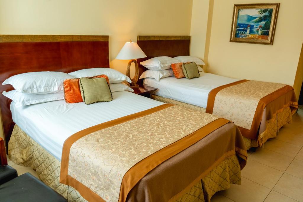 Postel nebo postele na pokoji v ubytování TOSCANA INN HOTEL