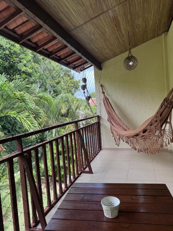 a porch with a hammock on a balcony at Flat Palmeira-Pipa Solar - centro in Tibau do Sul