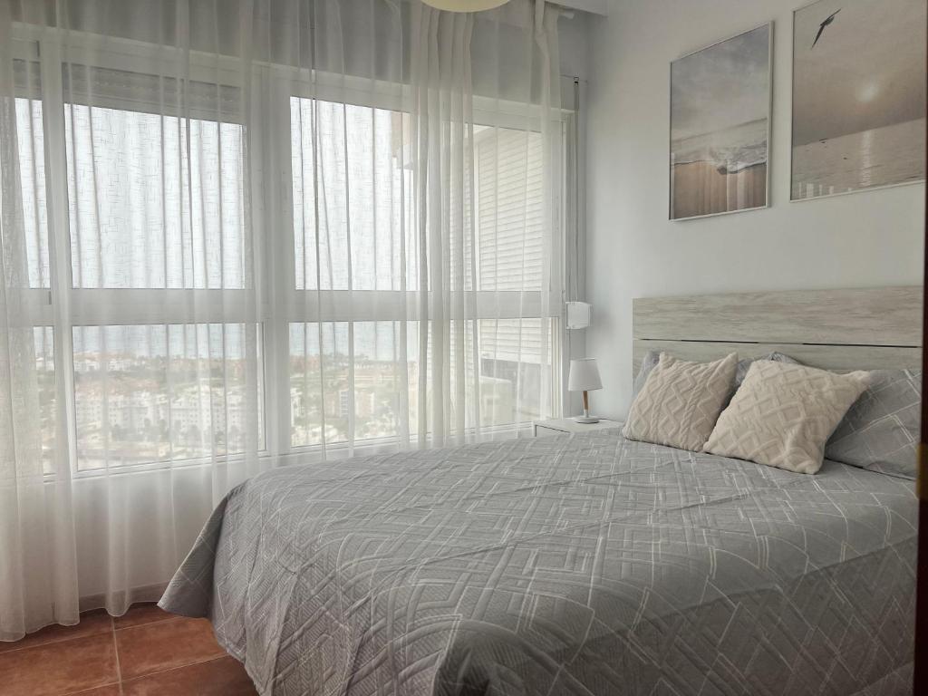 a bedroom with a bed and a large window at Apartamento Bellavista Close to the airport in Torremolinos