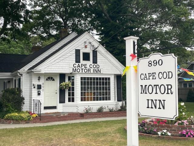 ein weißes Haus mit einem Schild davor in der Unterkunft Cape Cod Motor Inn in South Yarmouth