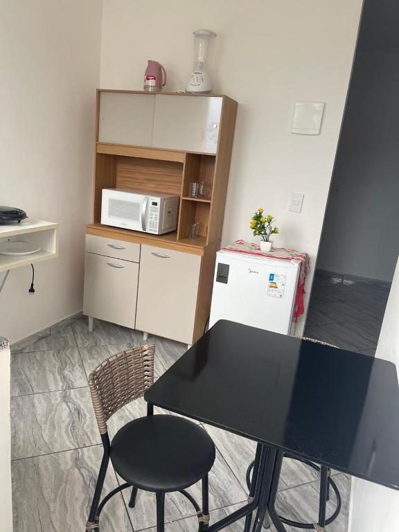 a small kitchen with a table and a microwave at Apartamento 5 km do Aeroporto in Brasilia