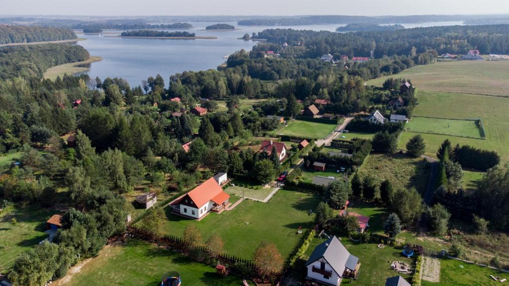 an aerial view of a small village with a lake at Domek Bajkowy Zakątek nad jeziorem Narie in Bogaczewo