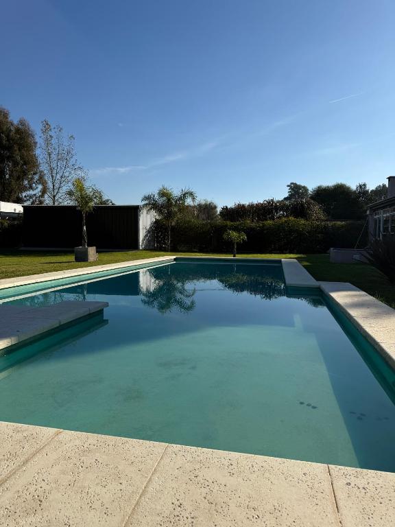 a swimming pool with blue water in a yard at Quinta en City Bell in City Bell