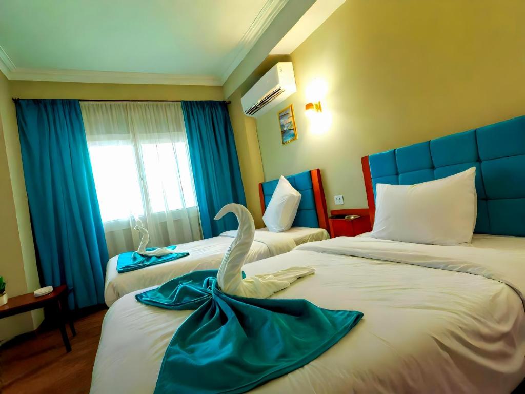 Postel nebo postele na pokoji v ubytování PYramiDS OaSiS ViEW HoTeL