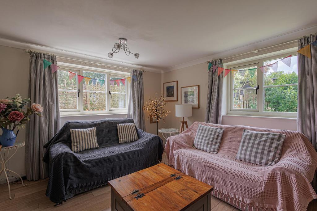 un salon avec un canapé et une table dans l'établissement Dreamy Suffolk Country Cottage Escape, à Aldeby