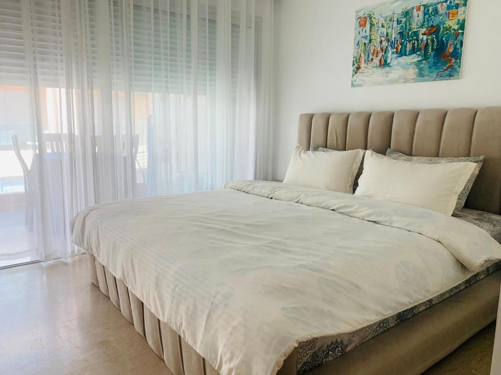 a bed in a bedroom with a large window at Bleu pearl imi ouaddar in Agadir