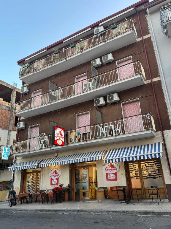 a building with tables and chairs in front of it at La Spagnola Affittacamere in Amantea