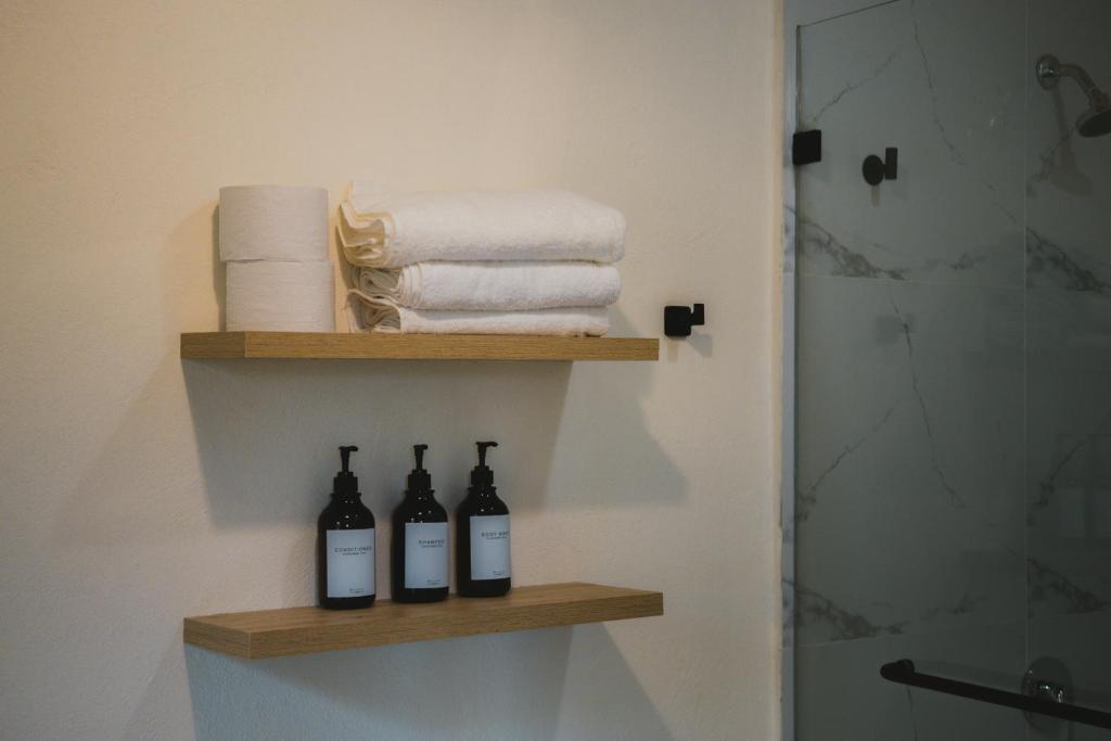 Baño con 2 botellas de vino en una estantería en Idilio Beach Apartments, en Montañita