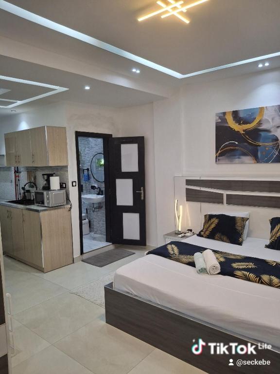 una camera da letto con un letto grande e una cucina di Seckebe Immo STUDIO JAUNE a Dakar