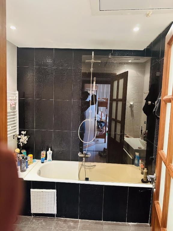 a bathroom with a bath tub and a mirror at VACANCE a MAHDIA in Bin Rhilouf