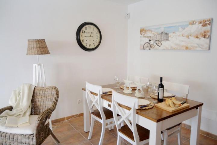 comedor con mesa y reloj en la pared en Domatsea Casa Provenzal, en Hospitalet de l'Infant