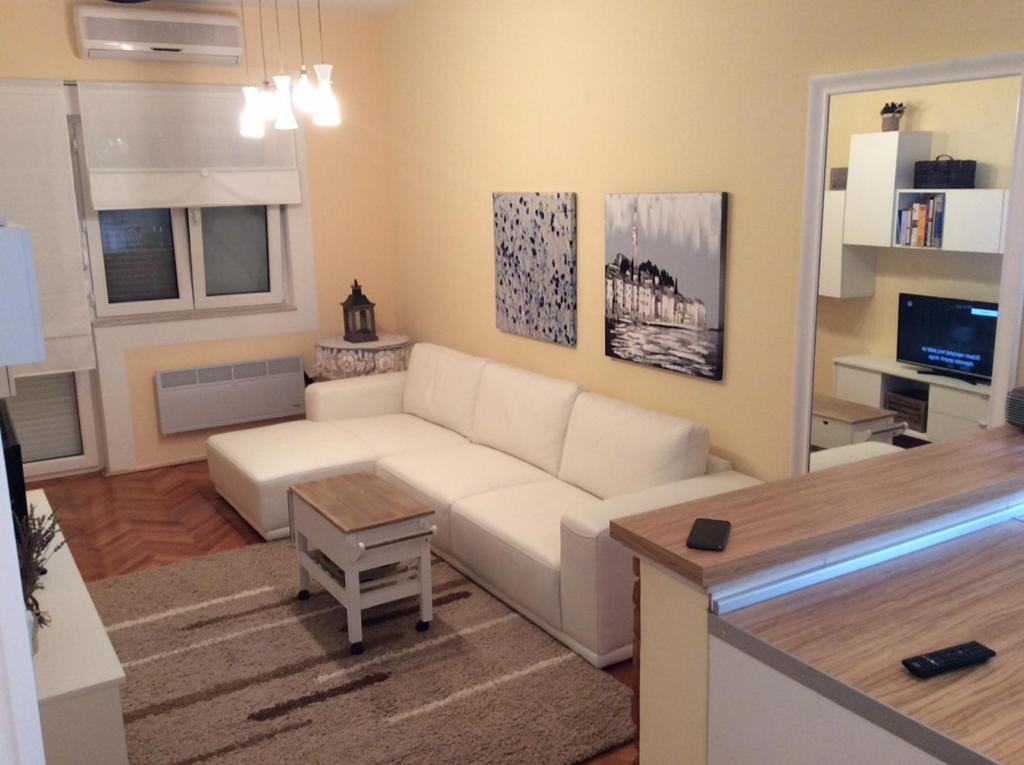 un soggiorno con divano bianco e tavolo di Apartment Satus a Podstrana