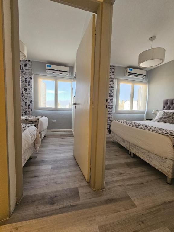 una stanza con due letti e due finestre di Departamento Santa Fe a Salta