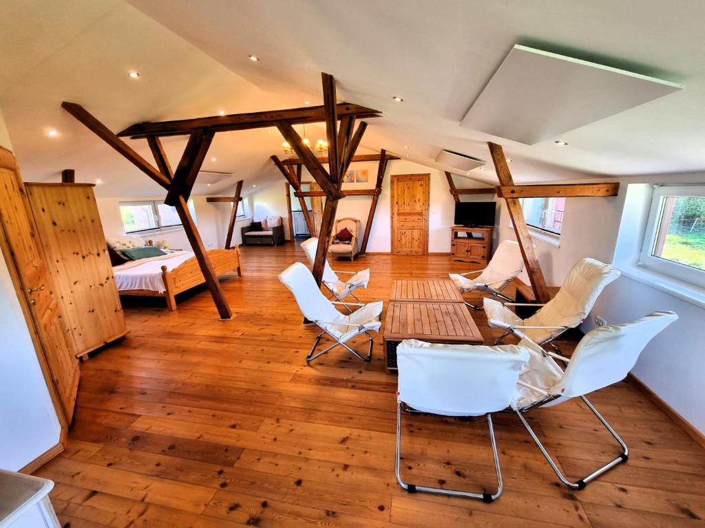 a room with white chairs and a table and a bed at Pugholz Suite in Hasselberg