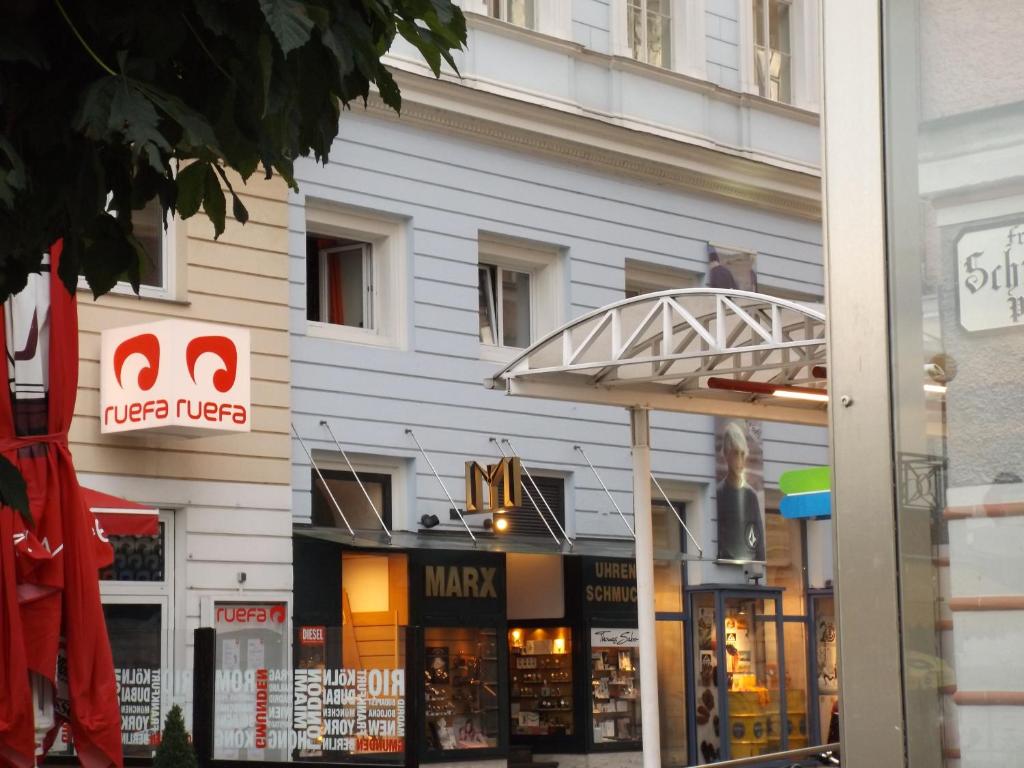 ein Geschäft vor einem Gebäude mit einem Schild darauf in der Unterkunft Oranges Apartment in Gmunden