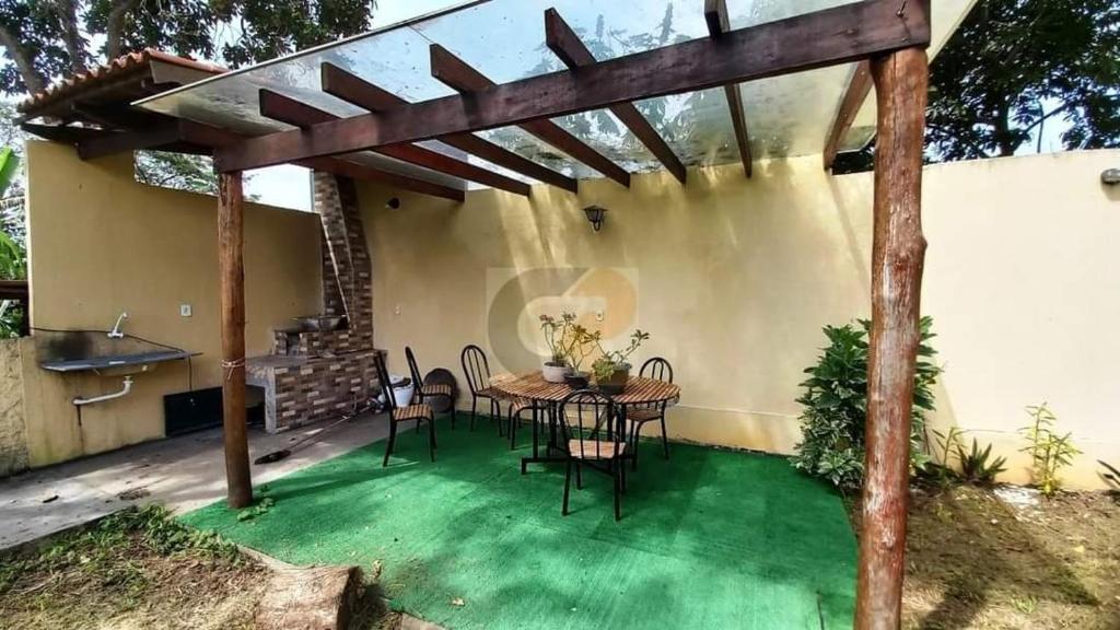 un patio avec une table et des chaises sur de l'herbe verte dans l'établissement Chácara Top, à Caldas Novas