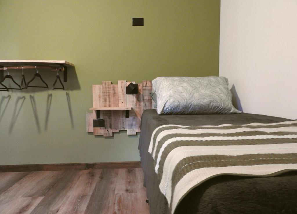 ein Schlafzimmer mit einem Bett und einem Holzboden in der Unterkunft Cabaña Kunl Villa La Angostura moderna y accesible in Villa La Angostura