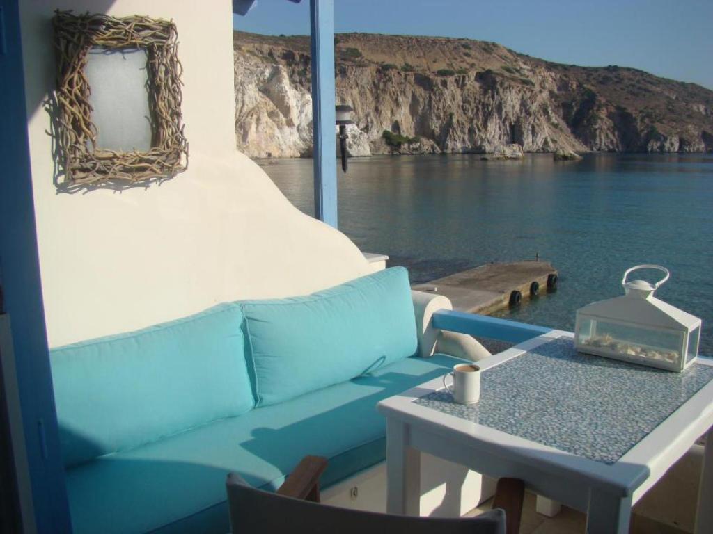 a blue couch and a table on a boat at Oneiro Beach Bungalow Studio in Plaka Milou