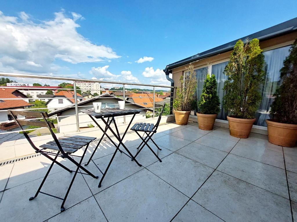 a patio with a table and chairs on a balcony at Bella Lubiana in Ljubljana