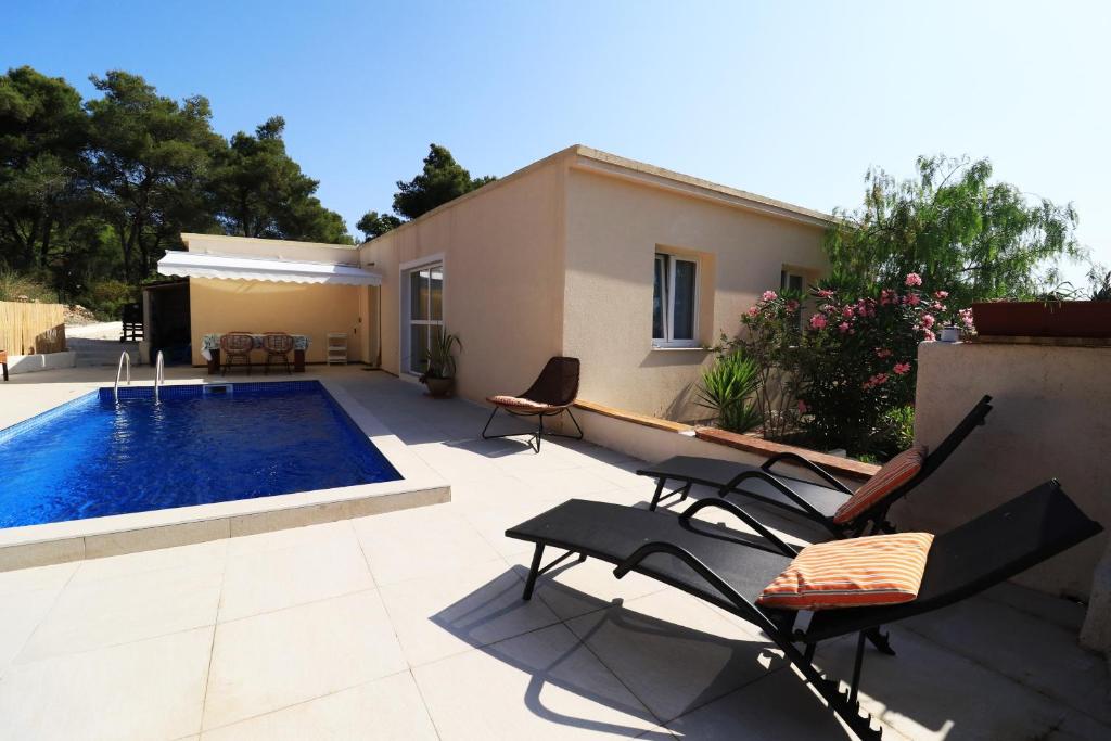 a patio with chairs and a swimming pool at Family friendly house with a swimming pool Rukavac, Vis - 24700 in Vis