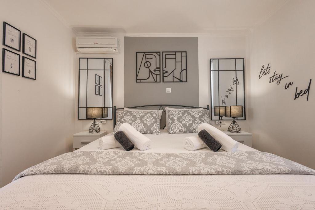 a bedroom with a large white bed with two lamps at The Neo-Classic Loft in Rhodes Town