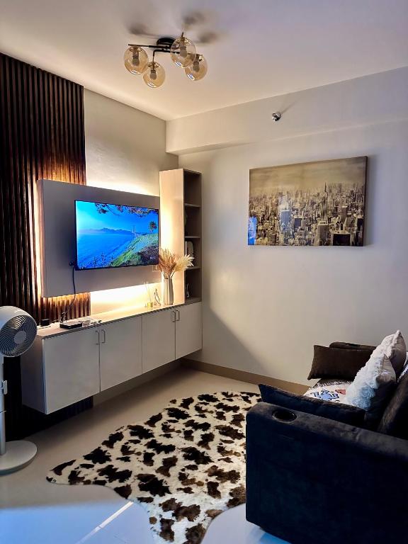 a living room with a couch and a flat screen tv at Tey Spot in Iloilo City