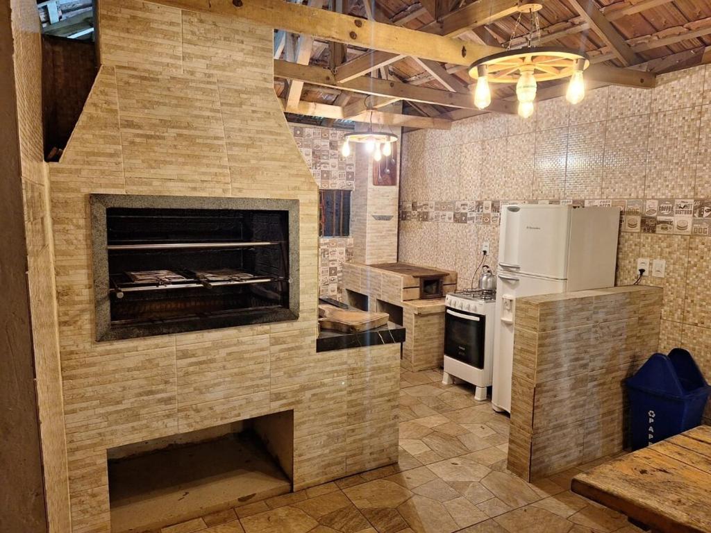 a kitchen with a large stone fireplace in a kitchen at Recanto Sampaio in Castro