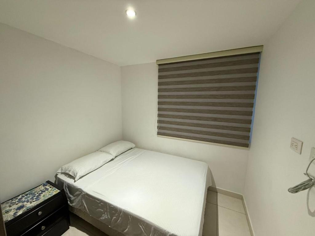 a small bedroom with a bed and a window at El rincón de Tonella Apartamento completo muy equipado in Ibagué