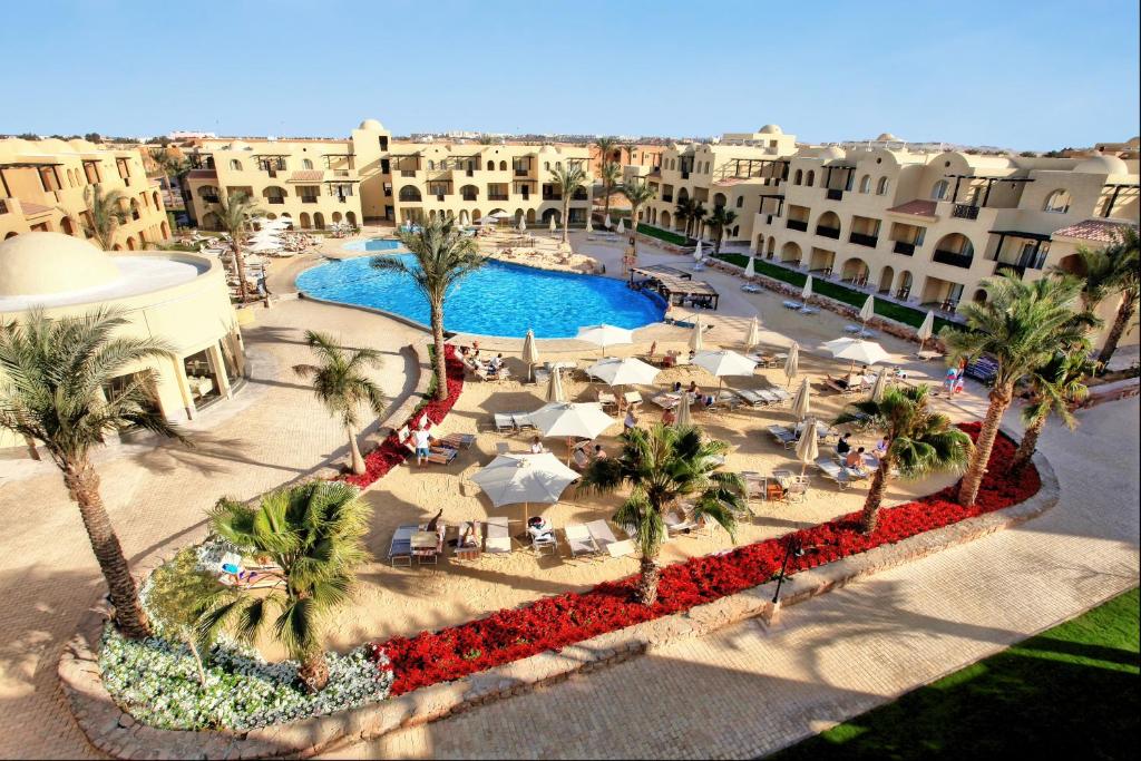 ein Luftblick auf ein Resort mit einem Pool und Palmen in der Unterkunft Stella Gardens Resort & Spa, Makadi Bay in Hurghada