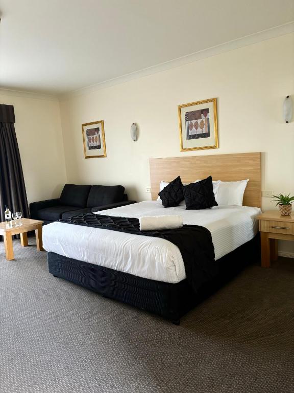 a hotel room with a large bed and a couch at Turners Vineyard Motel in Orange