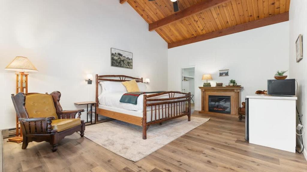 PonderosaCamp Nelson Lodge Room 6的一间卧室配有一张床、一把椅子和一个壁炉