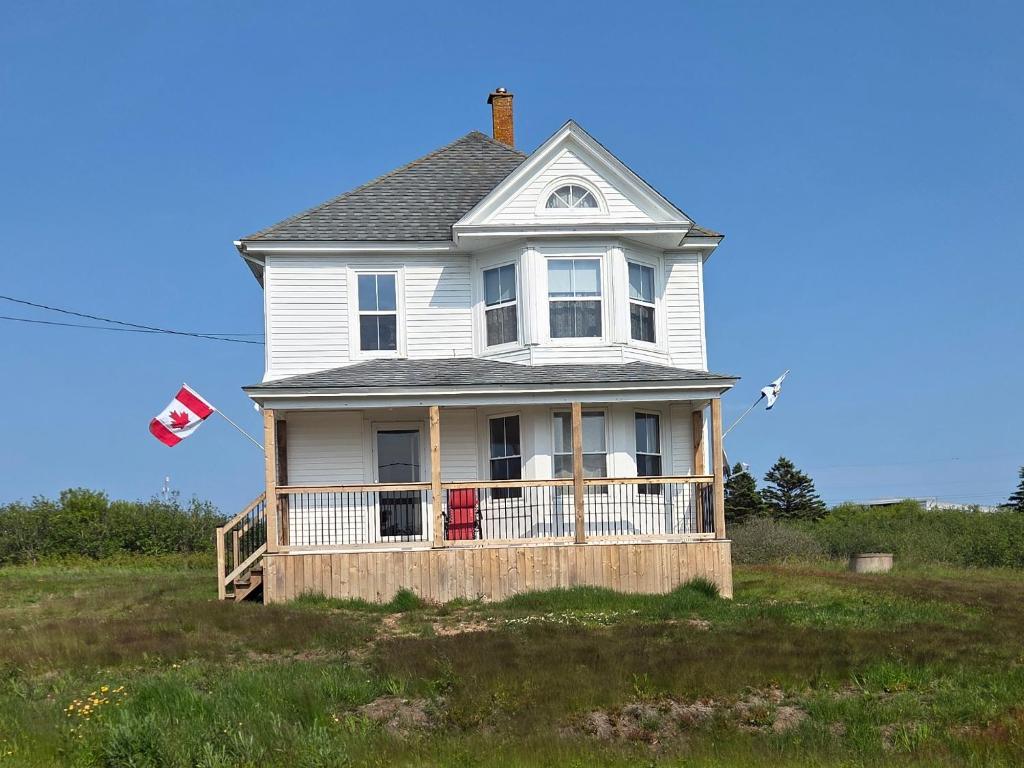 a house on top of a hill with a flag at East Ferry Bed and Breakfast in Brier and Long Islands