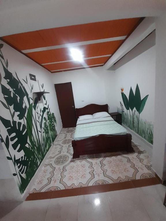 a bedroom with a bed with a painting on the wall at Finca MI FUNDO in Acacías