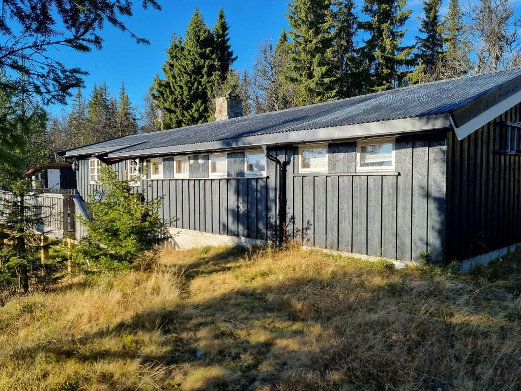 a building with a garage with trees in the background at Traditional Family Cabin Near Rabalen in Bagn