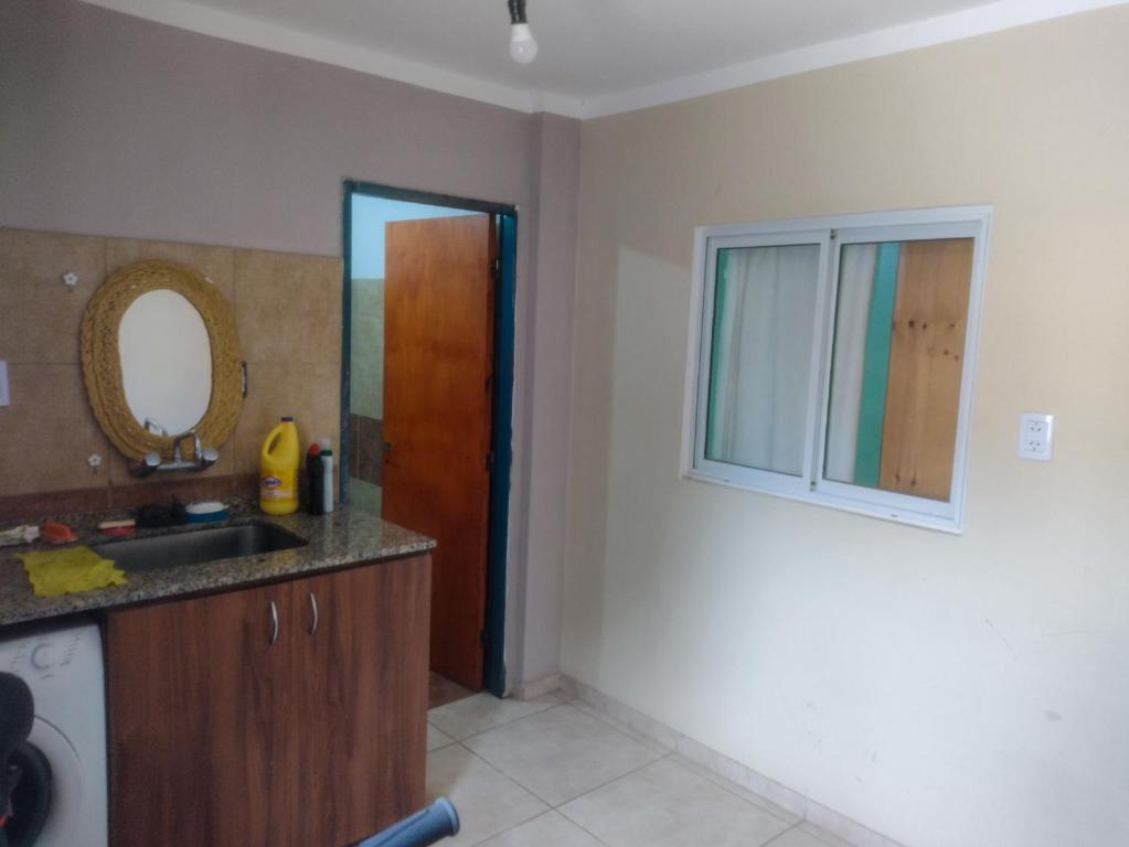 a kitchen with a sink and a mirror at Casita cómoda y de confianza in San Fernando del Valle de Catamarca
