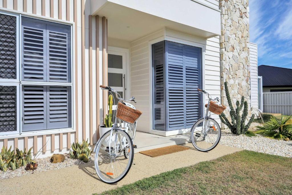 two bikes parked in front of a house at Cinema Pool Pets 4b2b Bargara Headlands in Pemberton