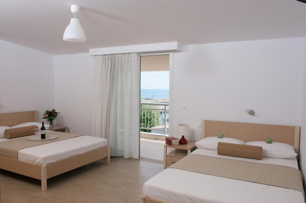 a bedroom with two beds and a view of the ocean at Protea's Seacret Sea View Studios in Paralia Katerinis