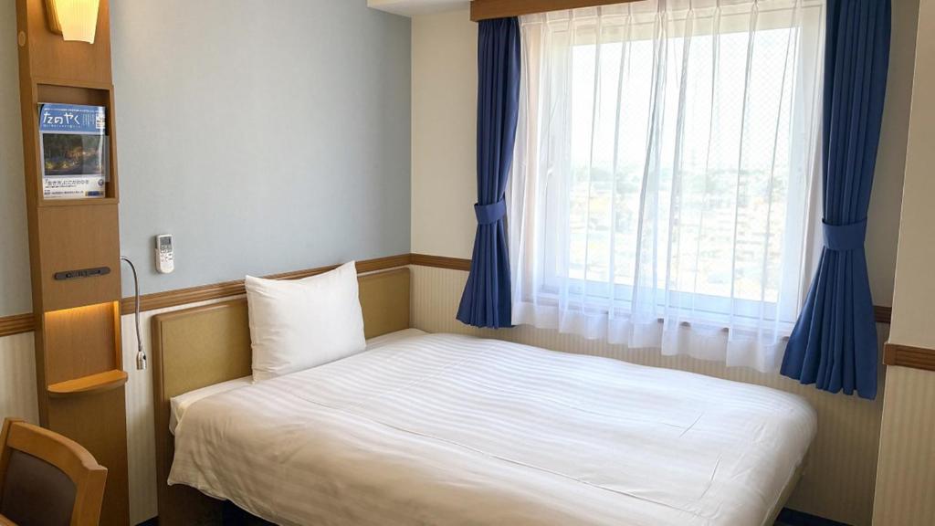 Postel nebo postele na pokoji v ubytování Toyoko Inn Wako-shi Ekimae