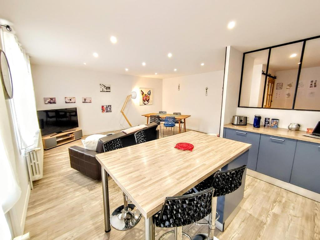 a kitchen and living room with a table and a couch at Une halte, Proche Notre-Dame in Rodez